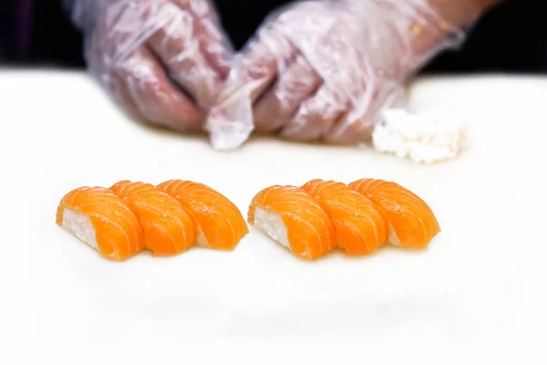 Somon Suşi seti Japon yemek şefi beyaz masada yemek pişiriyor..