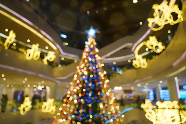 En üstteki noel ağacı dekoratif ışık üzerinde odaksız mavi yıldız, soyut bulanık arkaplan.