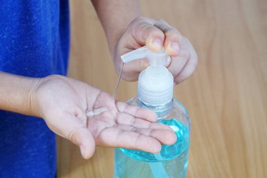 Çocuğun elleri hijyen için dezenfektan jeli pompa şişesi uygular. Virüsü, bakteriyi ve mikrobu önler. Yakın çekim..