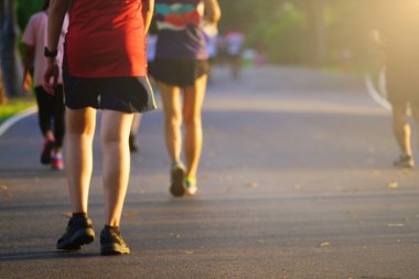 İnsanlar sabah ya da akşam açık hava parkında yürüyüş ve koşu egzersizleri yapıyorlar. Fotokopi alanı, yumuşak odak resim tonu..