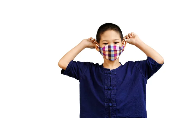 Küçük Asyalı bir portre. Kumaş maske takan sevimli bir çocuk. Hijyen için. Beyaz izole edilmiş arka plandaki çocuklar.