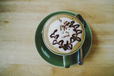 Sıcak Mocha - bir fincan kahve güzel Latte Art ahşap masa arka planda, sabah kahvaltı ile