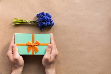 Sahte Babalar günü, Noel, doğum günü partisi için Flatlay tatil nane giftbox adam elinde mevcut ve Kraft kağıt üzerinde (sümbül) muscari çiçek buketi