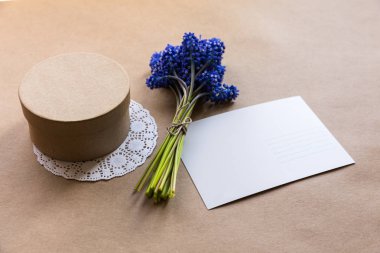 Boş kartpostal, zanaat mevcut giftbox ve muscari (sümbül) Kraft kağıt üzerinde çiçek buket kapatın