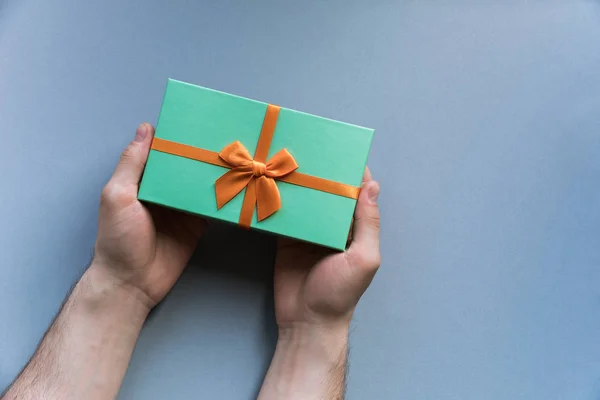 Férias Flatlay caixa de presente de hortelã presente em mãos de homem no pastel — Fotografia de Stock