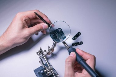 Mühendis derleme bir mikroçip cımbız ve Büyüteç ile lehim Pcb (baskılı devre kartı),