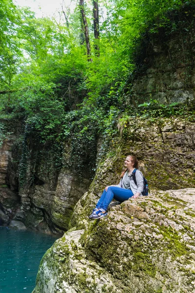 Oturma ve dağlarda gülümseyen Sportstyle seyahat kız