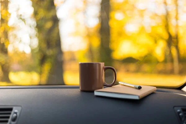 Autumn car trip. Woman feet in warm wool socks and cup of tea in the car