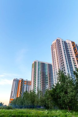 Açık mavi gökyüzündeki şehir manzarası: yaşamak için parlak renkli yüksek binalar