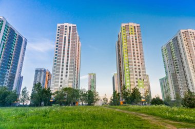 Açık mavi gökyüzündeki şehir manzarası: yaşamak için parlak renkli yüksek binalar