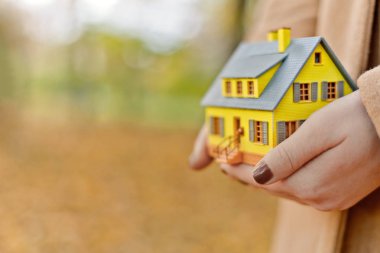 Mini sarı ev modeli ipotek teklifleri için kadınların elinde ve emlak veya iç tasarım satın alarak tasarruf edilen para
