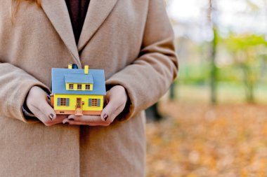 Mini sarı ev modeli ipotek teklifleri için kadınların elinde ve emlak veya iç tasarım satın alarak tasarruf edilen para