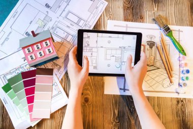 Tablet pedi, planları ve sanat araçları ile yassı iç tasarımcı