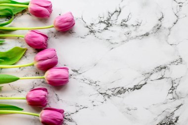 Mermer arka planda pembe laleler var.