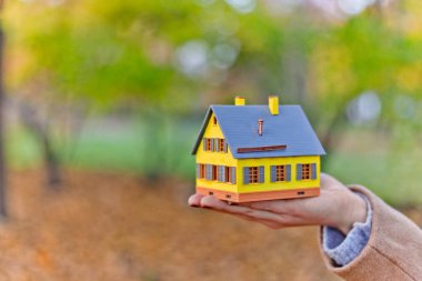 Mini sarı ev modeli ipotek teklifleri için kadınların elinde ve emlak veya iç tasarım satın alarak tasarruf edilen para