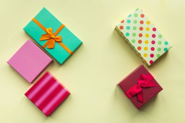 Pastel sarı arka planda anneler günü, Noel, doğum günü için hediye kutuları.