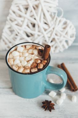 Sıcak kakao krema ve tarçın ile ahşap arka plan üzerinde sopa