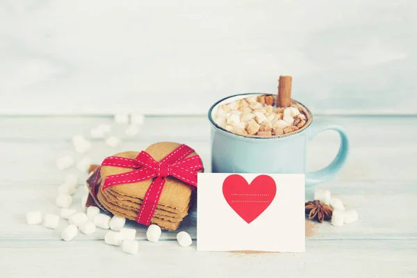 Cacau quente com marshmallows e paus de canela no fundo de madeira — Fotografia de Stock