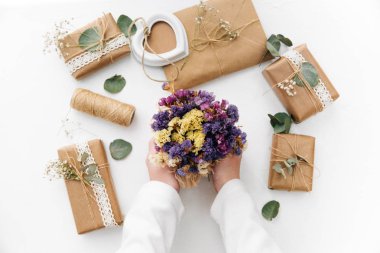 Çalışma alanı. Çiçekler holding eller. Ev yapımı hediye kutuları