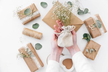 Çalışma alanı. Çiçekler holding eller. Ev yapımı hediye kutuları 