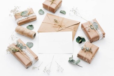 Mockup zarf, boş kartı, hediye kutuları ve kuru çiçekler. Düğün kavramı