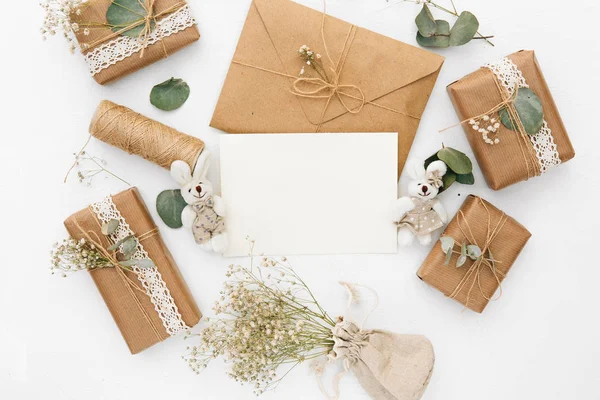 Burla con sobre, tarjeta en blanco, cajas de regalo y flores secas. Concepto de boda — Foto de Stock