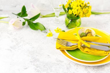 Festival Tablo ayarı ve yeşil ve sarı taze çiçeklerle dekorasyon. Paskalya arka plan 