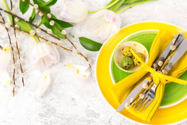 Festival Tablo ayarı ve yeşil ve sarı taze çiçeklerle dekorasyon. Paskalya arka plan 