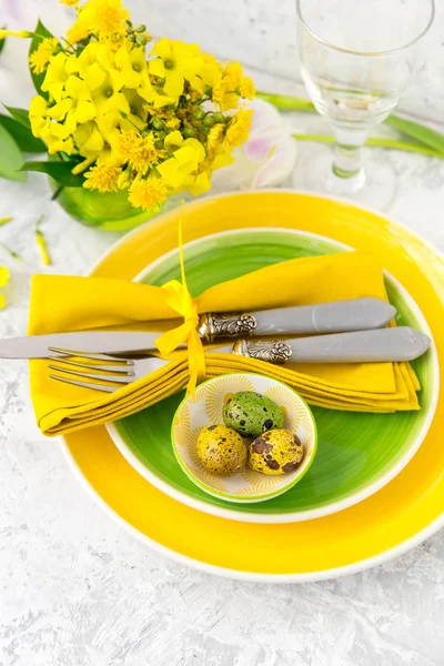 Feestelijke tafel instelling en decoratie met verse bloemen in groen en geel. Pasen-achtergrond — Stockfoto