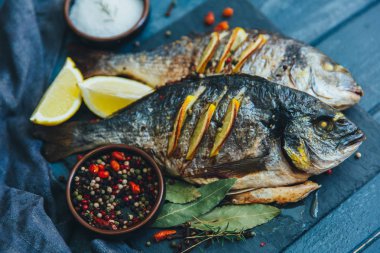 Ahşap arka plan üzerinde Eşkine balık baharatlar ile kavrulmuş 