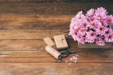 Çiçek ve hediye ahşap arka plan üzerinde ile natürmort. Metin için yer 