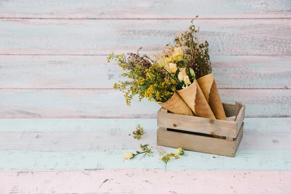 Kegel mit Blumen in Holzkiste. Kopierraum — Stockfoto