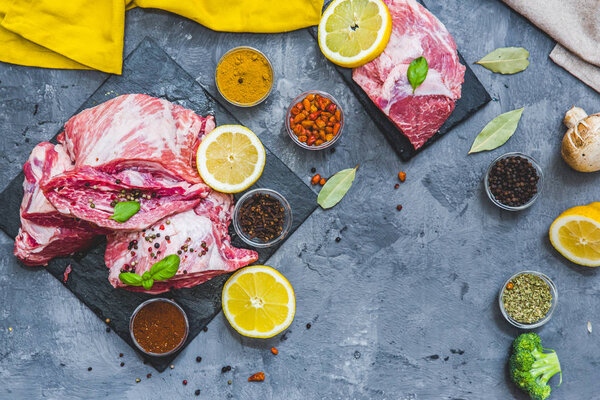 Fresh raw meat with spices over grey background
