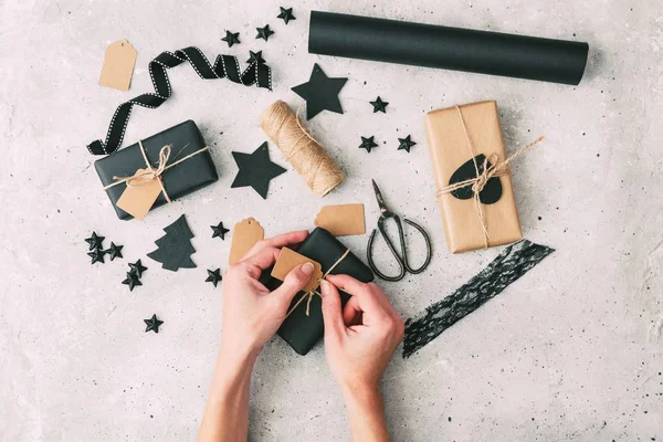 Hermosas manos femeninas se embalan regalo de Navidad en papel, cuerda. Caja de regalo en papel kraft marrón atado con cuerda . —  Fotos de Stock