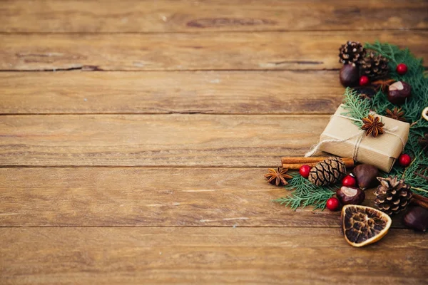 Fundo de Natal com cones de pinho e caixa de presente na mesa de madeira. Espaço de cópia, vista superior — Fotografia de Stock