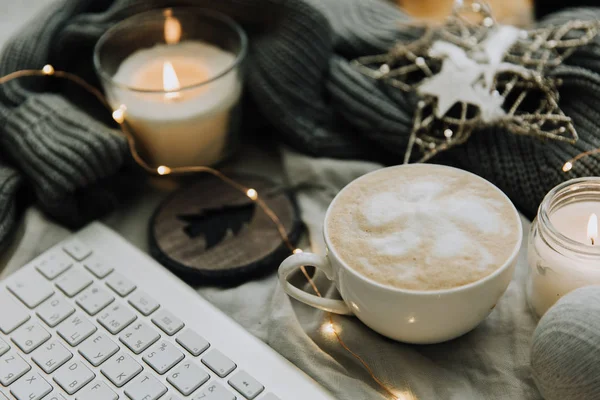 Cup of hot coffee and  keyboard. Cozy Christmas and New year