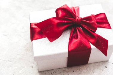 Şerit ve antika arka plan üzerinde kırmızı kalp ile hediye bağlıdır. Sevgililer günü