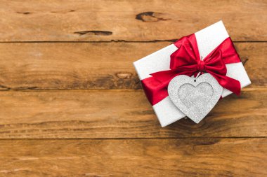 ahşap arka plan üzerinde kırmızı fiyonklu hediye kutusu