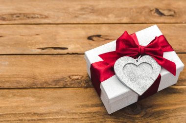 Tahta arka planda fiyonklu hediye kutusu