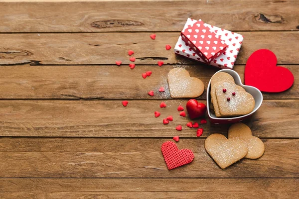 Heart shaped cookies with gifts over wooden background. Valentine day - homemade festive decorated pastry biscuits cookies