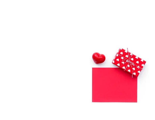 Valentine day composition: red gift box with bow, and empty card isolated on white. Top view.