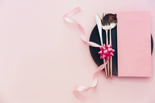 Накрываем на стол. Вид сверху, плоский на розовом фоне. Меню ресторана, приглашение на ужин или свадебная обстановка
