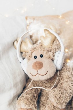 Kahverengi oyuncak kulaklıklarla. Şirin eğlenceli resimler. Müzik dinleme
