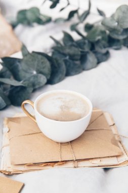 Harfler ve zanaat zarf ile yatakta kahve fincanı. Hipster sabah