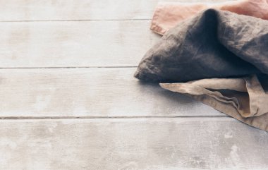 Kahverengi ve bej doğal renklerde keten kumaş peçeteler katlanmış ve ahşap arka plan üzerinde izole dize ile bağlı