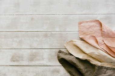 Ahşap zemin üzerinde üç doğal keten peçete. Pastel tonları 