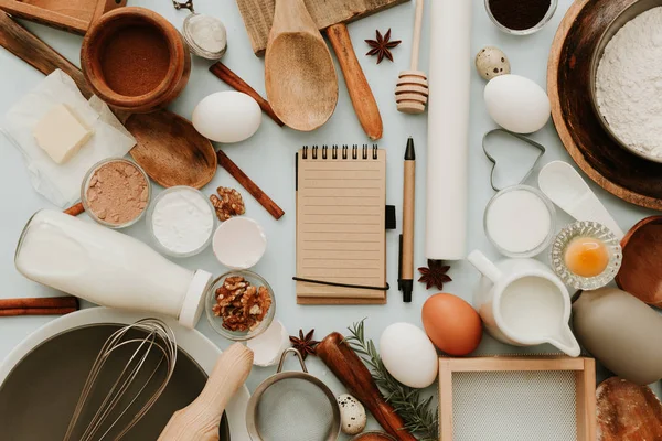Pişirme aletleri ve tarifi Malzemeler üzerinde pastel açık mavi renkli. Düz uzay görüntüleri genel gider metin yatıyordu. Tarifi kitap metin uzay görüntüleri.