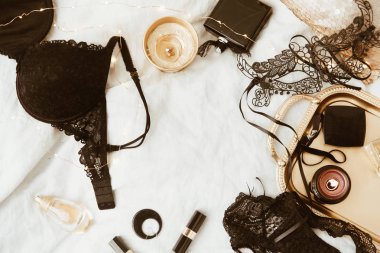 Üstten Görünüm moda altın ve siyah aksesuarları. Maske, kahve, ruj ve dantel iç çamaşırı. Kadın gerekli Aksesuar ve düz lay iç çamaşırı set.