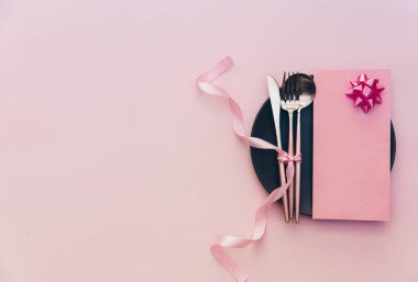 Zarif tatil sofra pembe bir arka plan üzerinde kart ve çatal bıçak takımı closeup ile yer. Restoran akşam yemeği ya da menü kavramı.