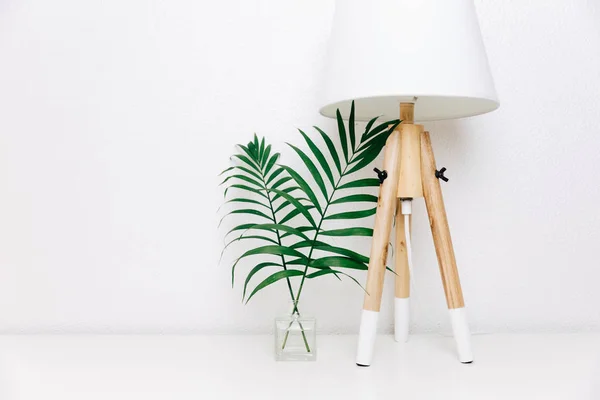 Nordic living room. Scandinavian lamp and tropical leaves. Eclectic Minimal home decor